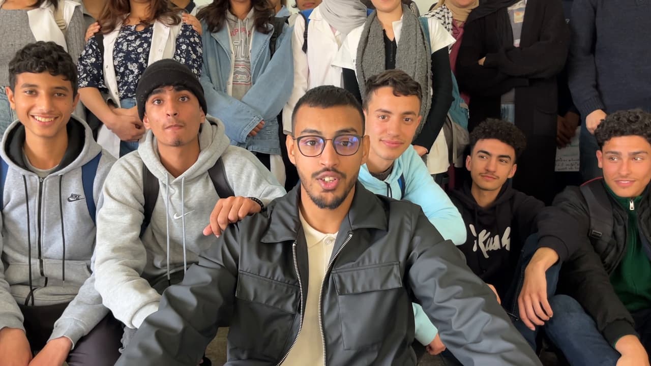 A mentor filming a group selfie with students
