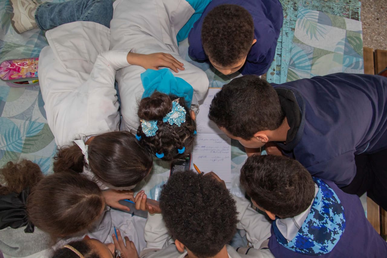 Students huddled around a tablet