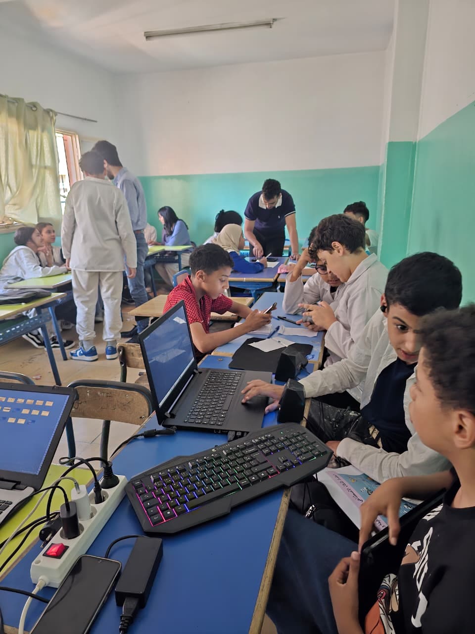 Students coding together on one keyboard during the hackathon